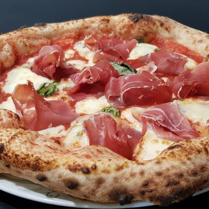 une belle Pizza avec du jambon de parme au dessus
