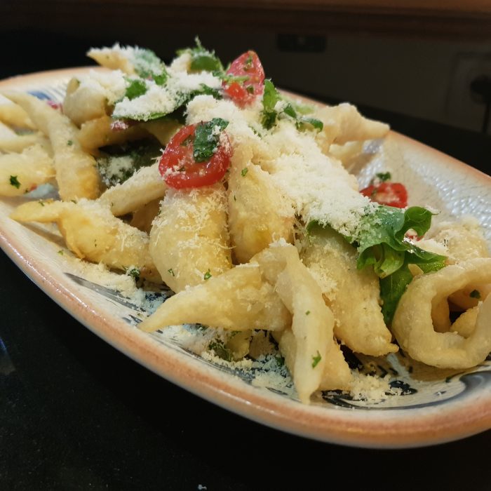 Plat de pâtes avec du parmesan, du basilic et des tomates cerises au dessus