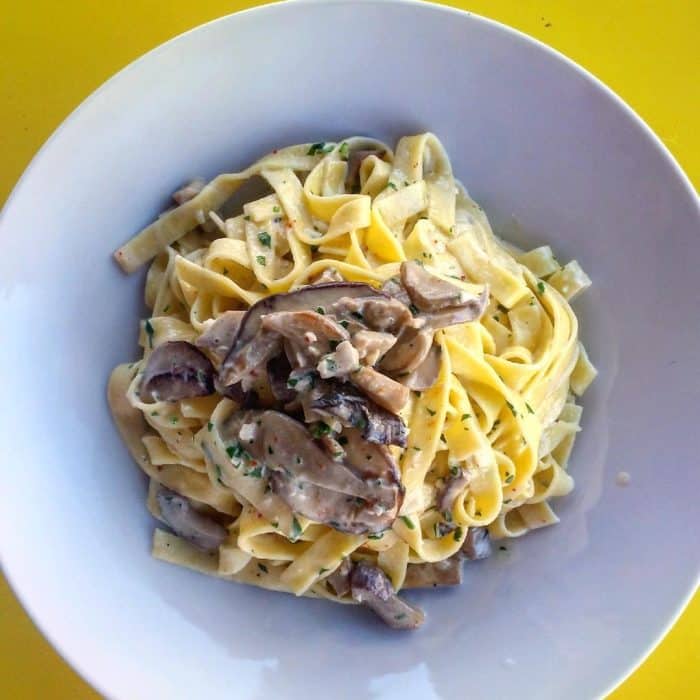 Plat de pâtes au champignons joliment présenté vue d'en haut