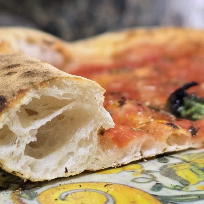 L'intérieur d'une croûte de pizza vue de près avec une belle aération de la pâte